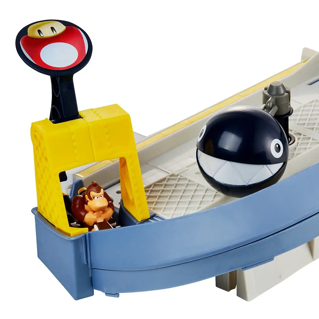 Close-up of Hot Wheels Mario Kart Chain Chomp Track Set highlighting Donkey Kong figure in his kart at yellow Mushroom Slam Launcher beside the large black Chain Chomp obstacle.