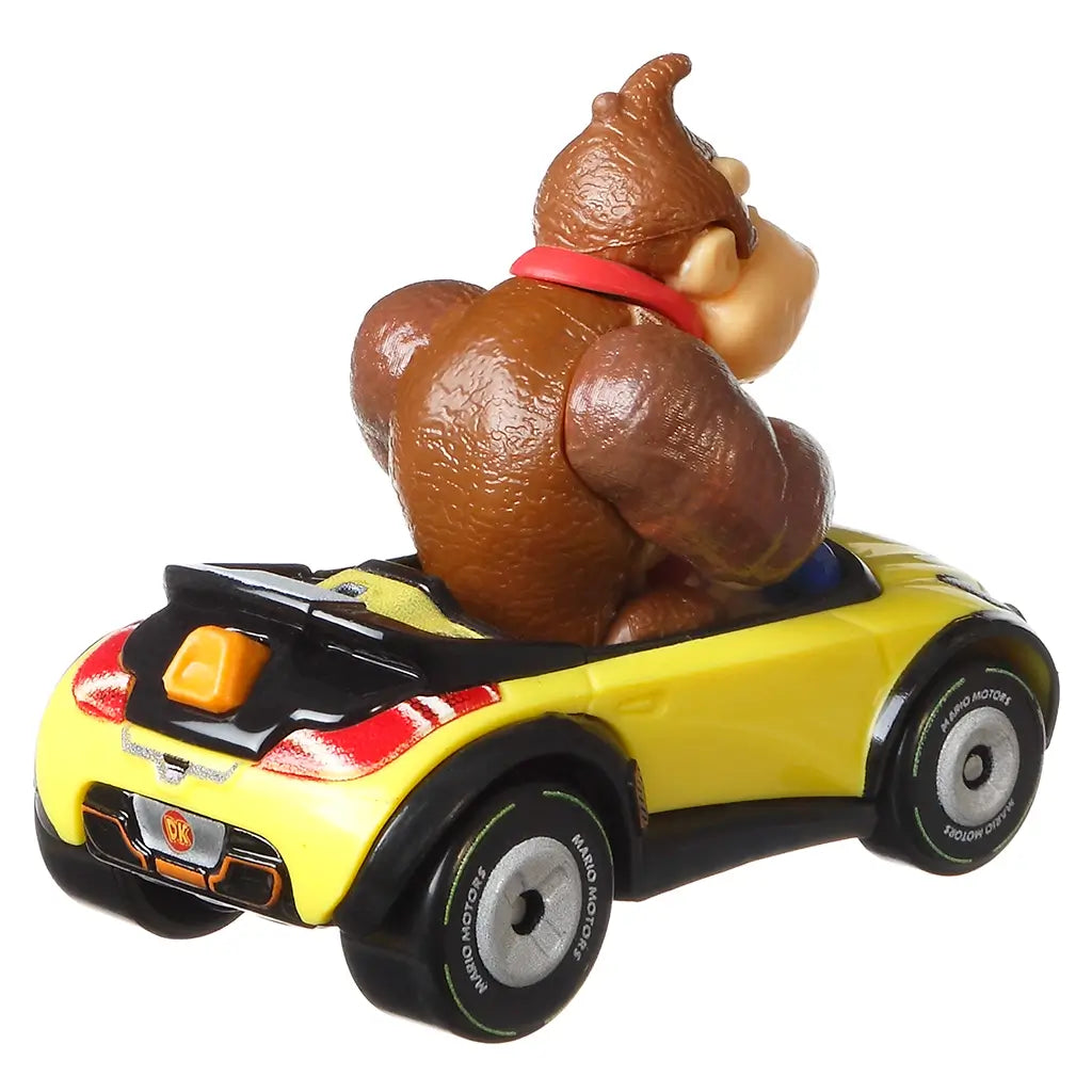 Rear angled view of Hot Wheels Donkey Kong Sports Coupe toy with yellow body, detailed taillights, DK logo on license plate, and Donkey Kong figure sitting inside.