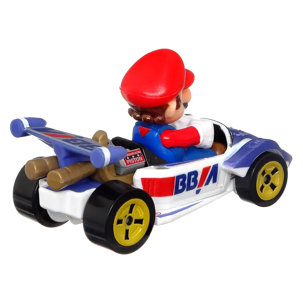 Rear angled view of Hot Wheels Mario Kart diecast showing Mario in a blue and white Circuit Special kart with detailed spoiler, Mushroom Piston engine, and yellow-spoked wheels.