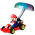 Hot Wheels Mario Kart diecast figure of Mario in a bright red and blue pipe frame kart, steering under a raised metallic rainbow parachute glider.