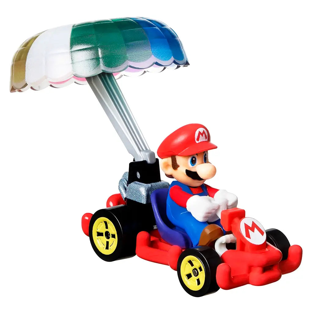 Front angled view of Hot Wheels Mario Kart diecast toy with Mario in a red kart, wearing his red cap and gloves, steering under a colorful parachute glider.