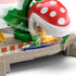 Yoshi kart speeds through Hot Wheels Mario Kart Piranha Plant track as the large red chomping plant lunges down near the finish, creating a dramatic racing action moment.