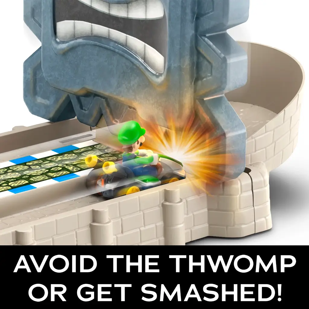 Hot Wheels Mario Kart Thwomp Ruins track set shows Luigi in a green kart narrowly avoiding a crashing gray Thwomp block on a castle-style race track with text warning of danger.