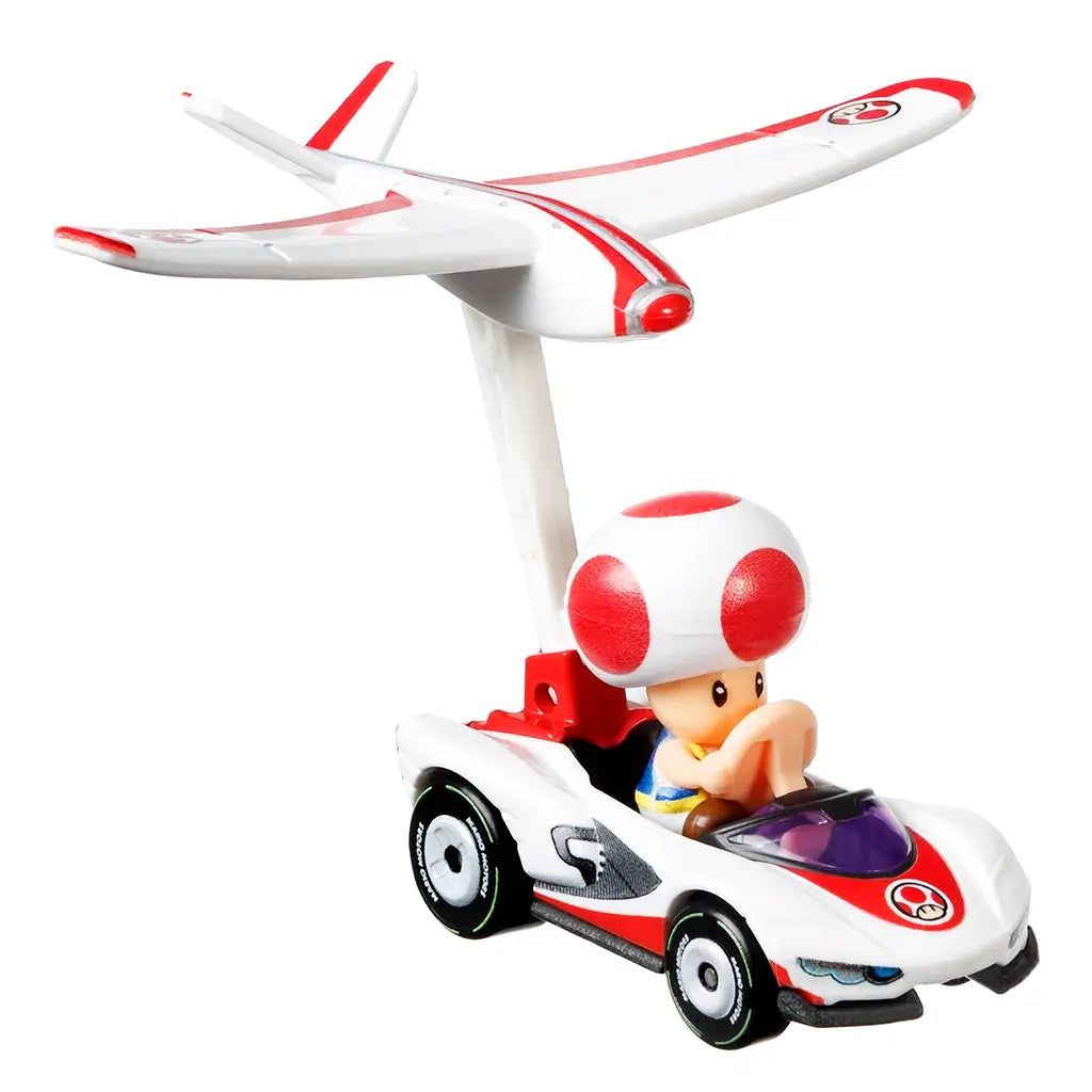 Front view of Hot Wheels Mario Kart Toad P-Wing diecast vehicle displays Toad driving sleek white kart with red details, purple windshield, and raised white glider for flight mode.