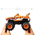 Hands holding Hot Wheels Tiger Shark RC monster truck measuring 7.57 inches long, with orange shark-themed body, black chassis, and oversized treaded tires for off-road play.