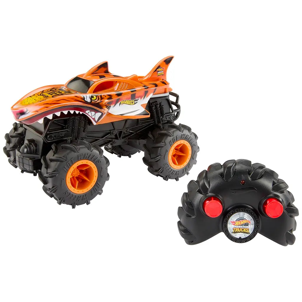 Hot Wheels Tiger Shark RC monster truck with black treaded tires and orange shark-themed body, displayed alongside its black remote controller with two large red buttons.