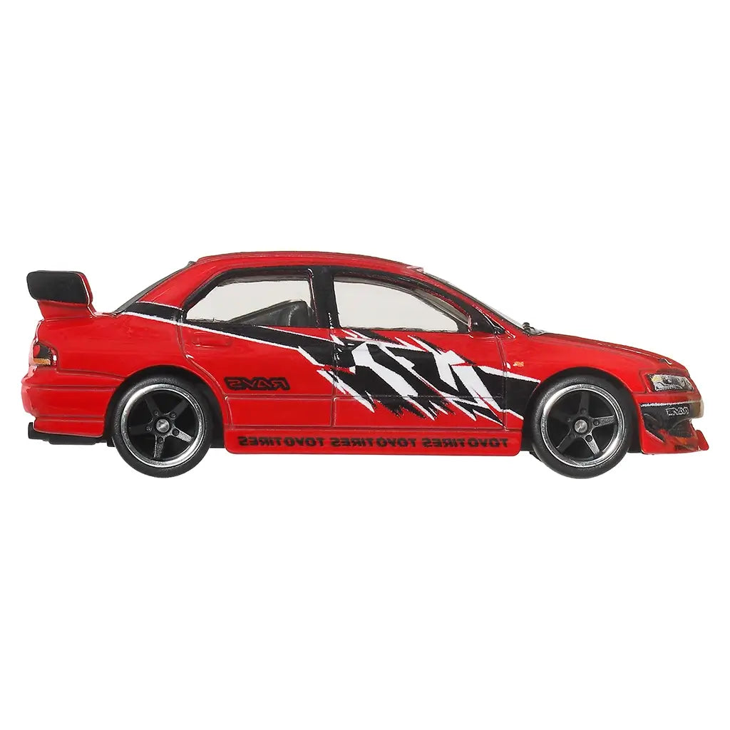 Hot Wheels Mitsubishi Lancer Evolution IX diecast car in bright red metal with sharp side graphics, four-door performance sedan profile, black wheels, side skirts, and tinted windows, presented in a clean side view on white.