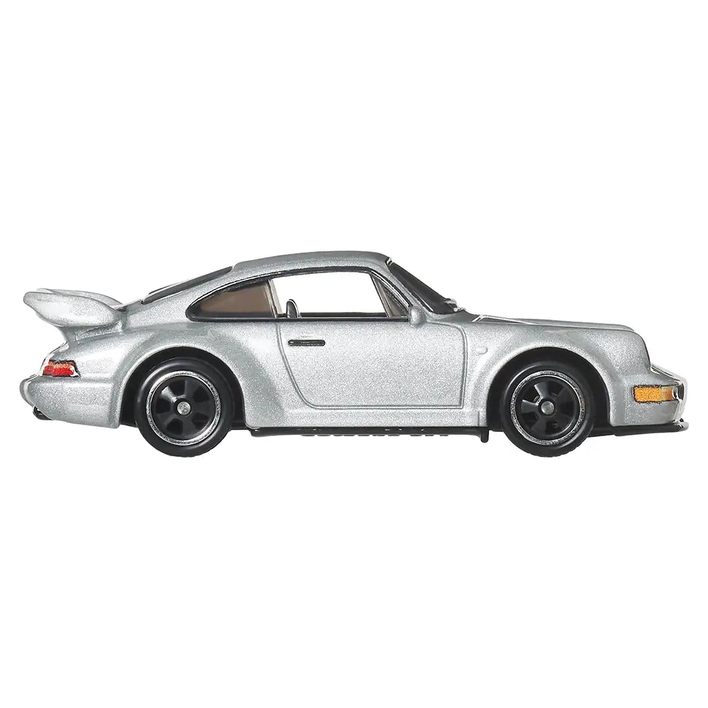 Hot Wheels Porsche 911 Carrera RS 3.8 diecast car in metallic silver metal with smooth side panels, iconic two-door coupe profile, black wheels, flared arches, and tinted windows, presented in a clean side view on white.