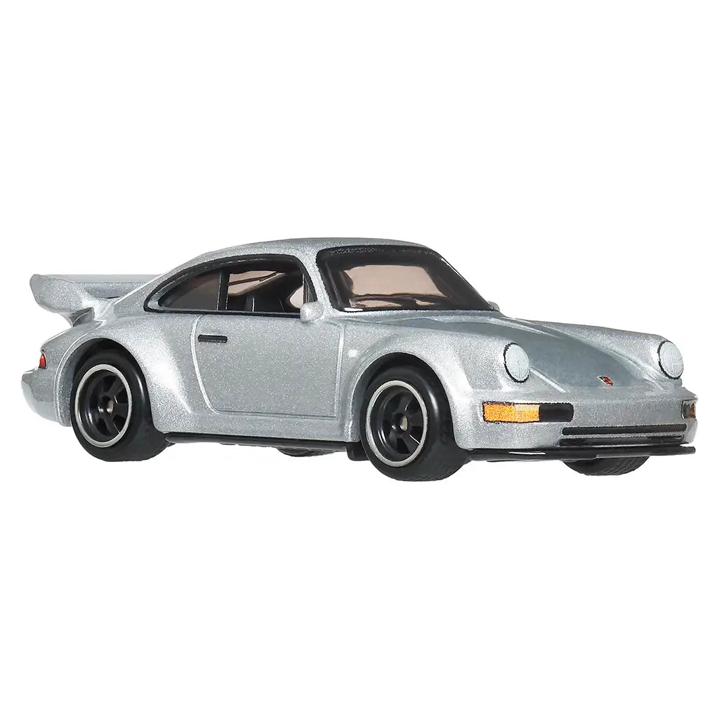 Hot Wheels Porsche 911 Carrera RS 3.8 diecast car in metallic silver metal with smooth sculpted body, classic coupe silhouette, black wheels, rear whale-tail spoiler, and clear windows, isolated on a white background.