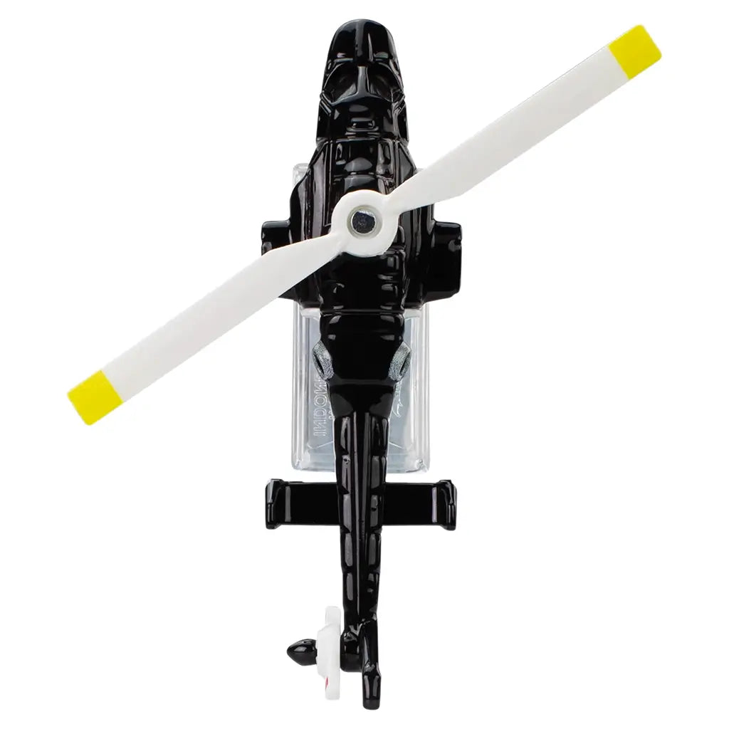 Hot Wheels Premium Airwolf helicopter top view highlighting the black die-cast metal body, white main rotor blades with yellow tips, tail rotor detail, and streamlined military design, presented from above on a white background.
