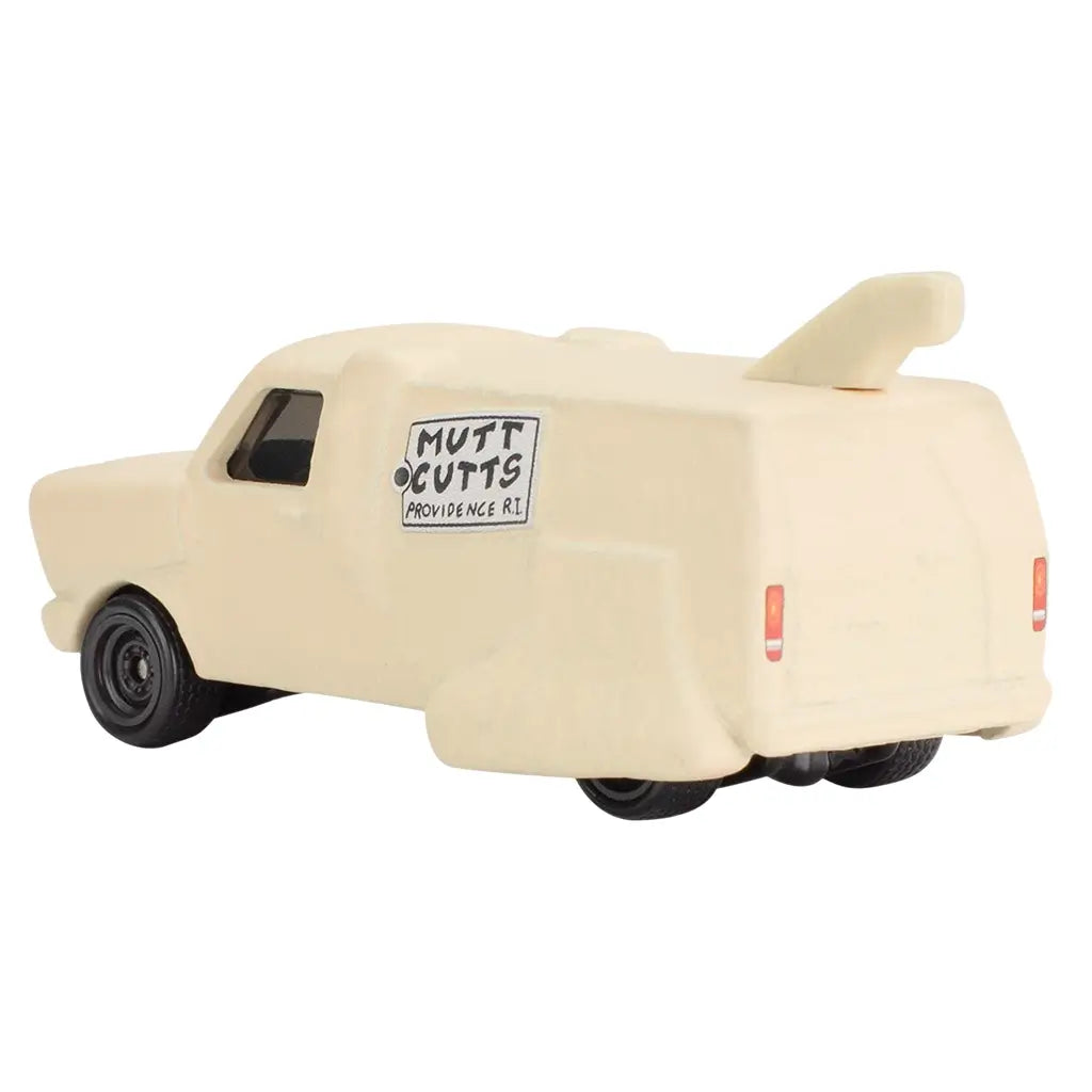 Rear angled view of beige Hot Wheels Dumb and Dumber 'Mutt Cutts' van, showing tail on roof, rear lights, black wheels, and side 'Mutt Cutts' Providence RI logo decal.
