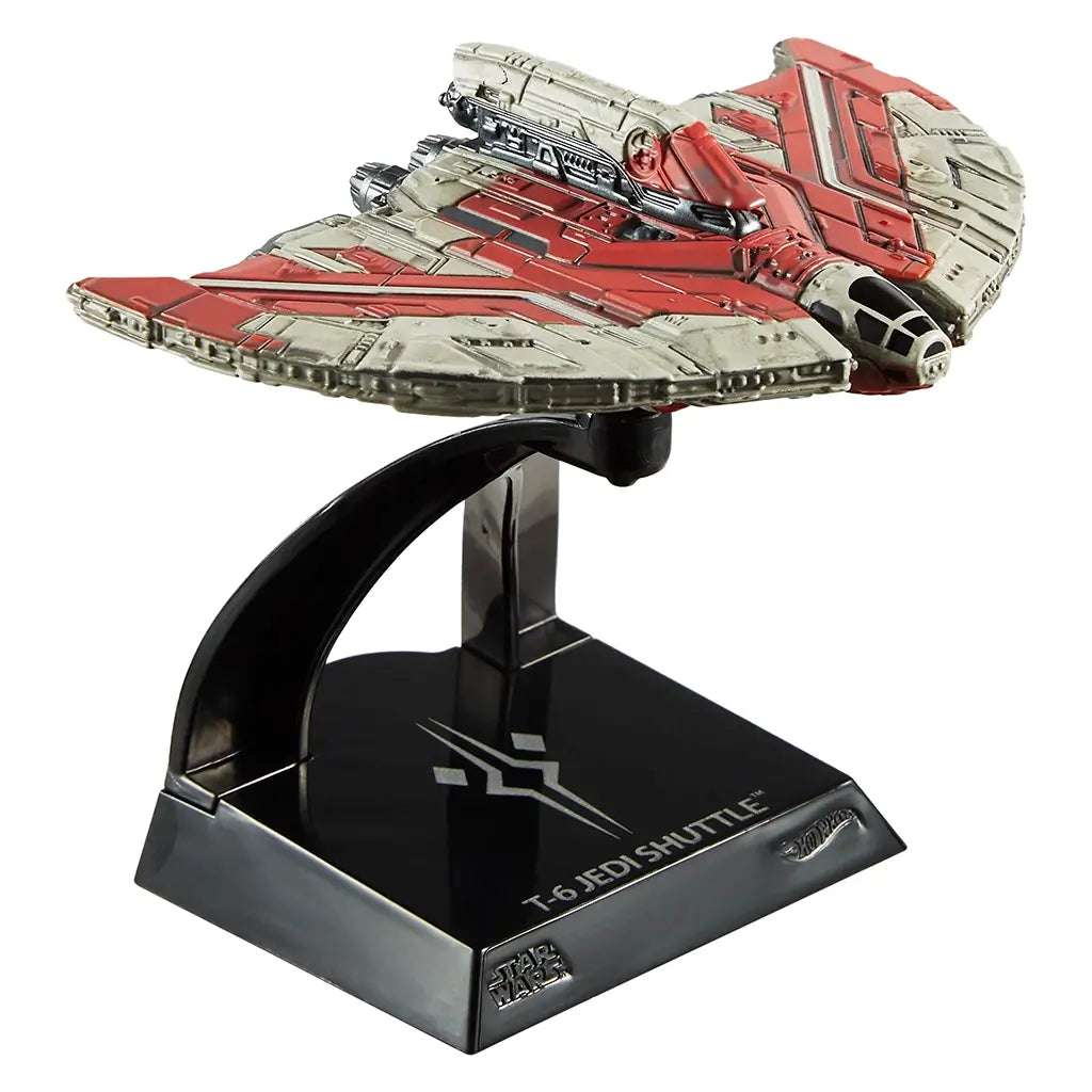 Front-angled view of the Hot Wheels 2025 Star Wars Ahsoka Tano’s T-6 Jedi Shuttle die-cast ship on its black display stand, featuring weathered red and grey paint, detailed cockpit, and textured wing panels.