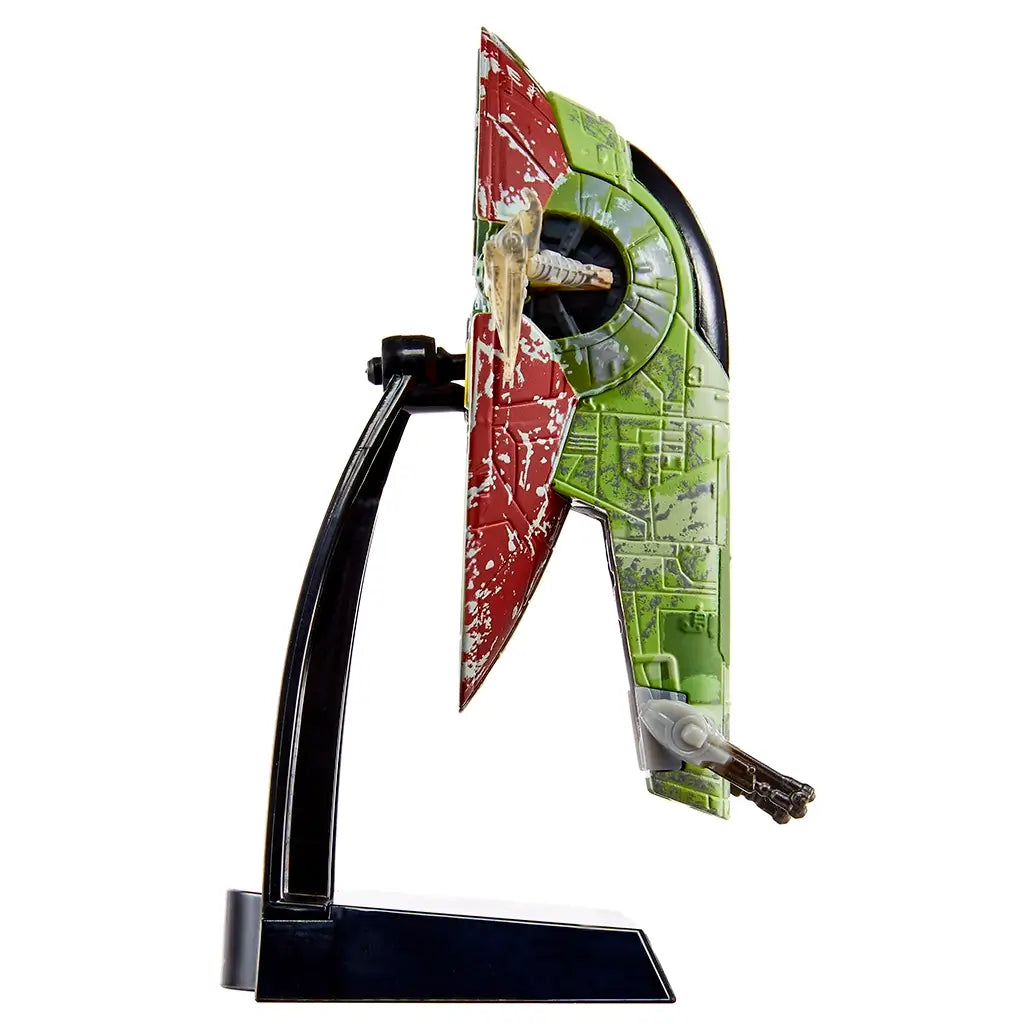 Hot Wheels Star Wars Boba Fett’s Starship side profile highlighting the slim vertical silhouette, green and red distressed plastic armor, side-mounted cannons, and curved black stand used for stable display.