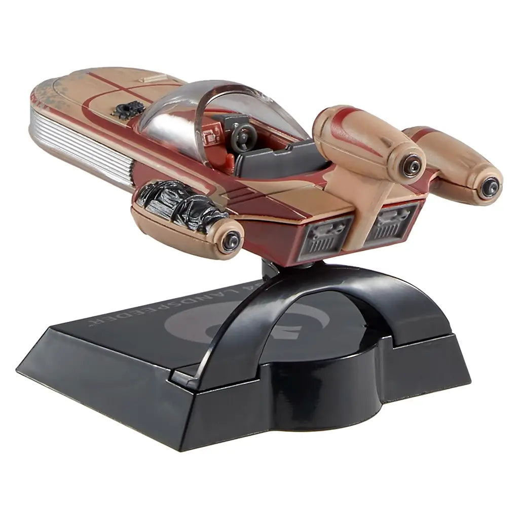Hot Wheels Star Wars X-34 Landspeeder rear angled view showing tan plastic engines, red accent striping, molded exhaust vents, and cockpit seating, supported by a black curved stand for upright display.
