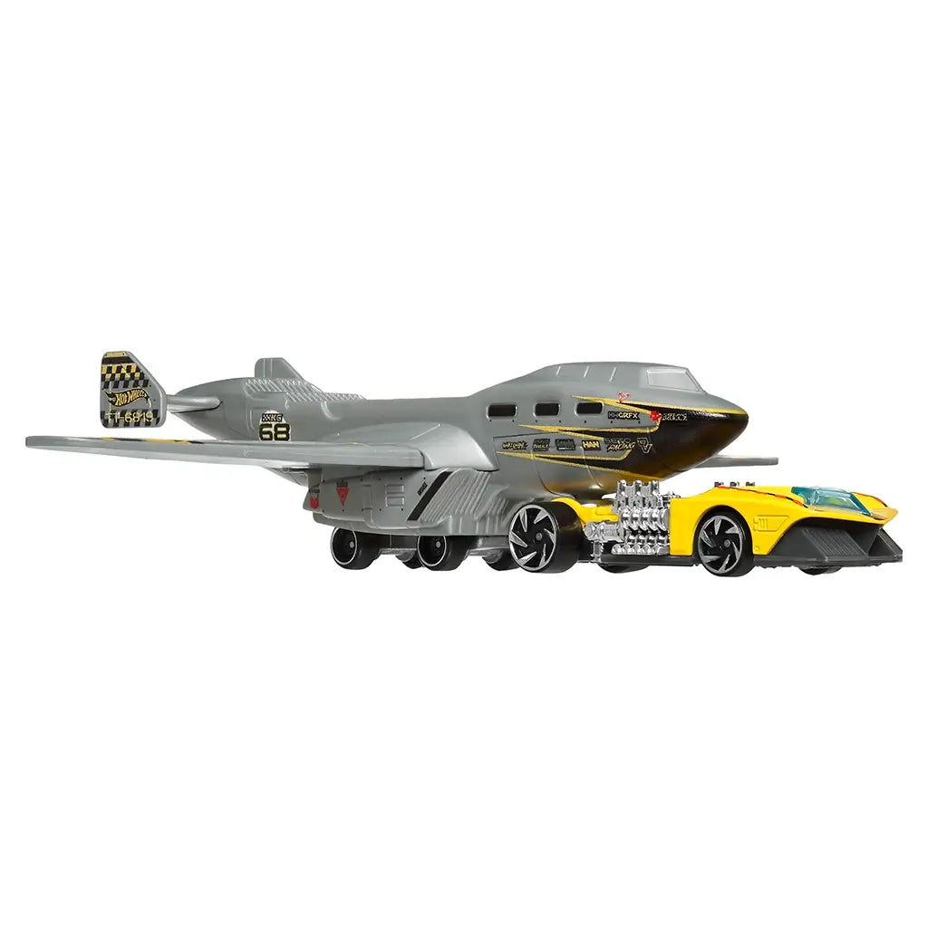 Hot Wheels Turbulence Tug vehicle set in an angled view featuring a gray aircraft inspired hauler with wing details, rolling wheels, and a bright yellow race car positioned beneath the nose on white.