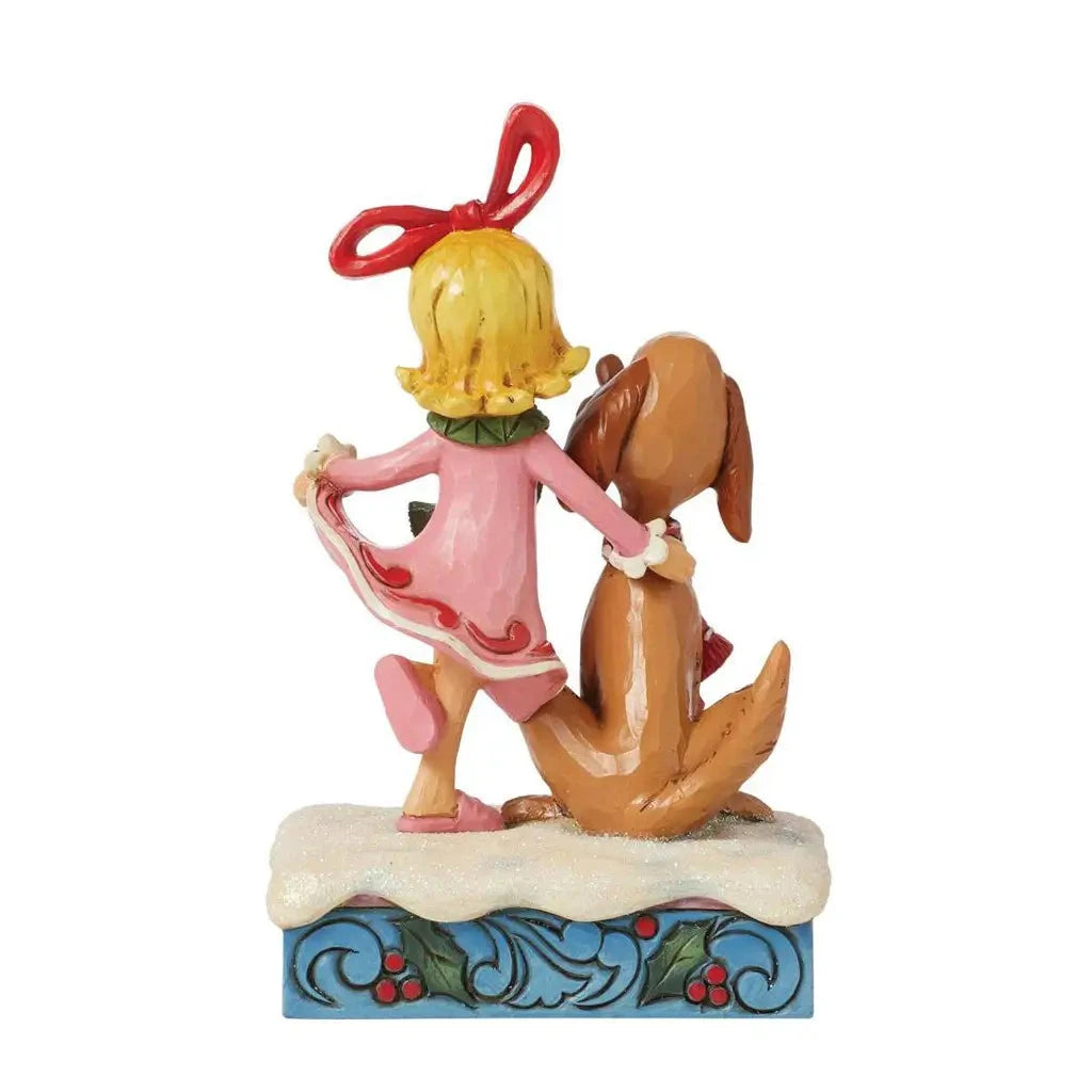 Rear view of Jim Shore figurine showing Cindy Lou Who holding her dress and Max seated beside her, on a snow-covered base with holly design.