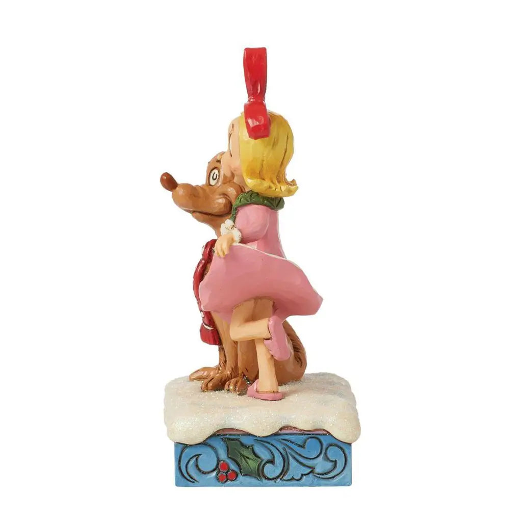 Alternate side view of Jim Shore figurine with Cindy Lou Who raising her leg and hugging Max, both on a snow-dusted base with blue and holly detailing.