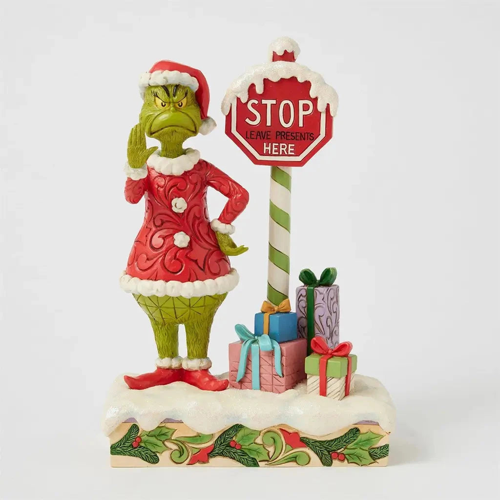 Jim Shore Grinch LED figurine with stop sign light turned off, showing detailed holiday scene with Grinch and colorfully wrapped presents.