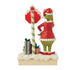 Rear view of Jim Shore Grinch LED figurine showing Grinch by candy cane pole with stacked presents and snow-covered base with holly details.