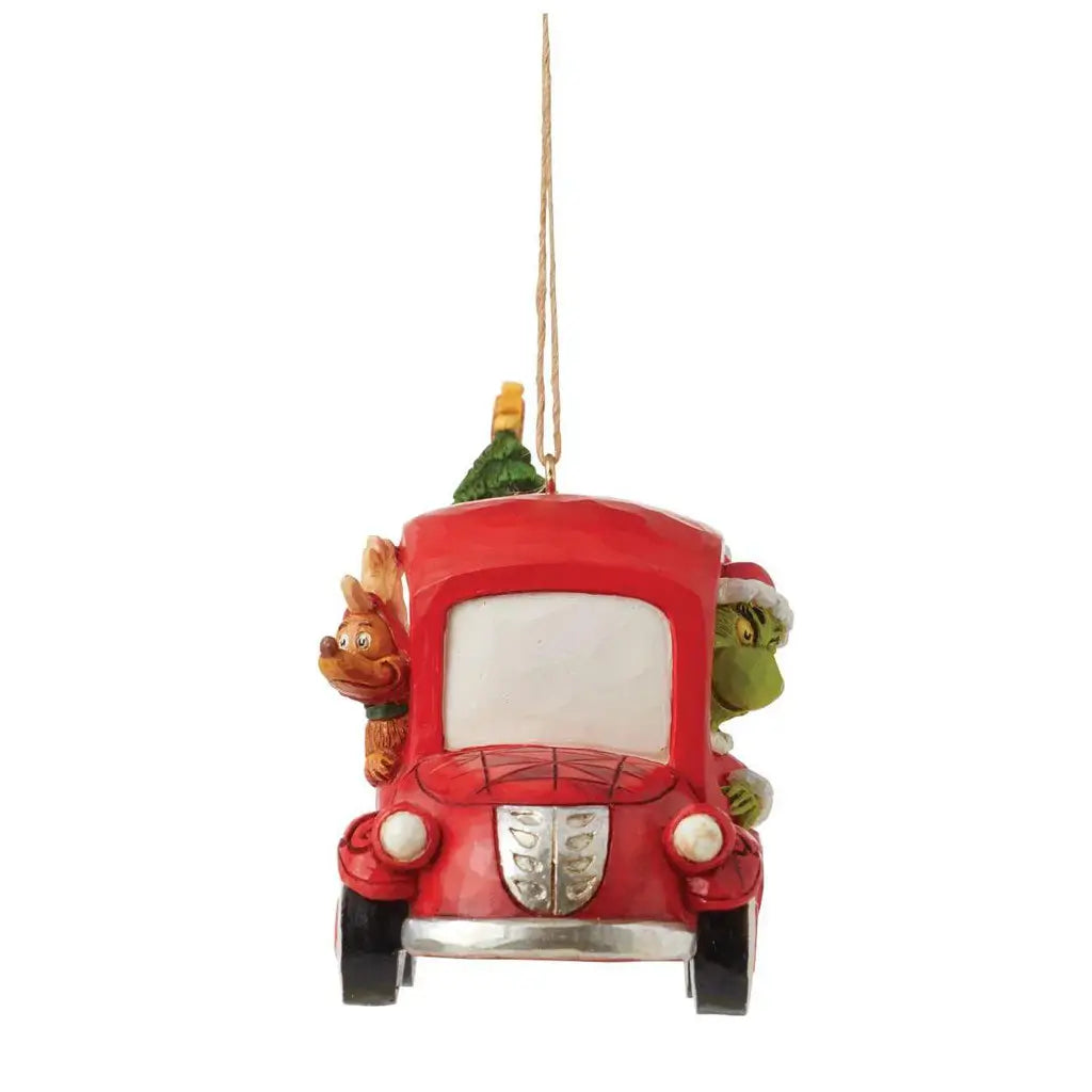 Front view of Jim Shore red truck ornament with Max and Grinch peeking out from windows, loaded with a tree and holiday presents.