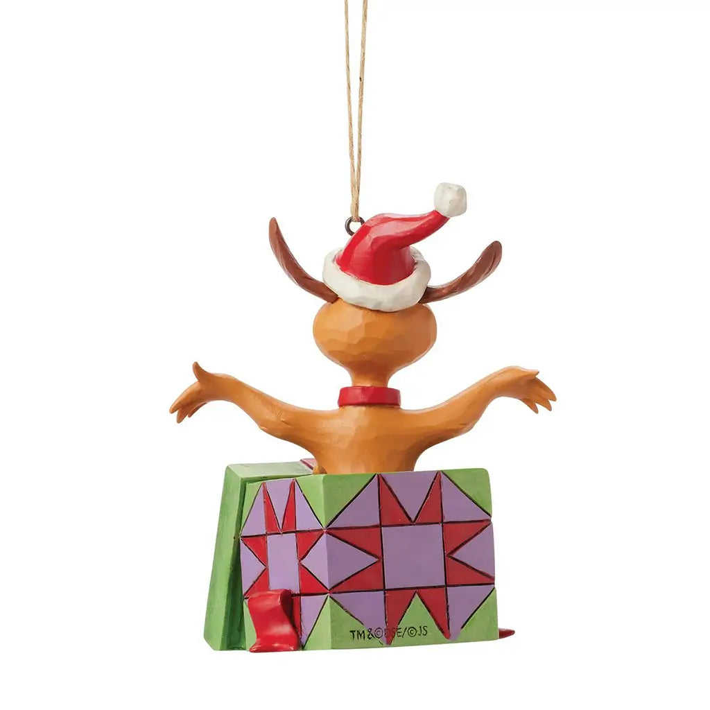 Rear view of Jim Shore Max ornament figurine popping out of a colorful gift box, wearing a red Santa hat with arms outstretched and a sculpted festive bow.