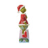Alternate side view of Jim Shore "Merry Grinchmas" figurine with the Grinch in red and green outfit posed beside decorated holiday text display.