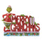 Front view of Jim Shore "Merry Grinchmas" figurine with the Grinch leaning on red block letters, decorated with holly, a present, and festive base.