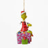 Side view of Jim Shore Grinch ornament featuring the Grinch in a Santa outfit sitting on a pink present, tangled in colorful Christmas lights.