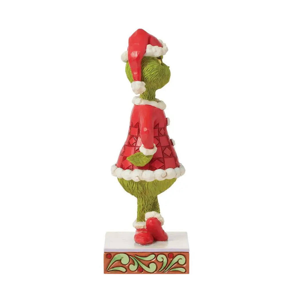 Side view of Grinch figurine in red Santa outfit with white trim, standing on a decorative base; hand-painted collectible from the Jim Shore Christmas series.
