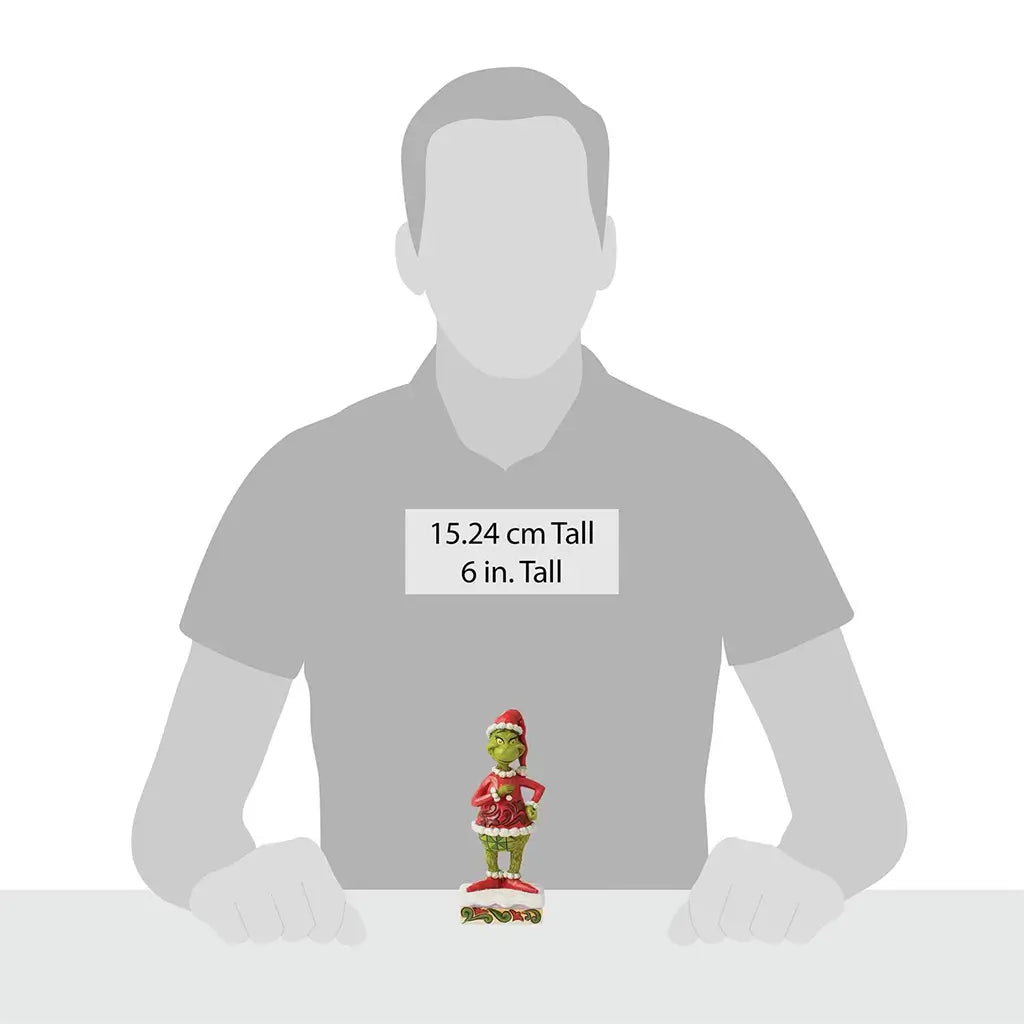Size comparison image showing Jim Shore Grinch figurine at 6 inches tall, displayed on a table in front of a silhouette for scale reference.