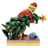 Back view of Jim Shore Grinch figurine in red Santa coat with white trim, holding decorated green Christmas tree on holly-trimmed base, against plain white background.