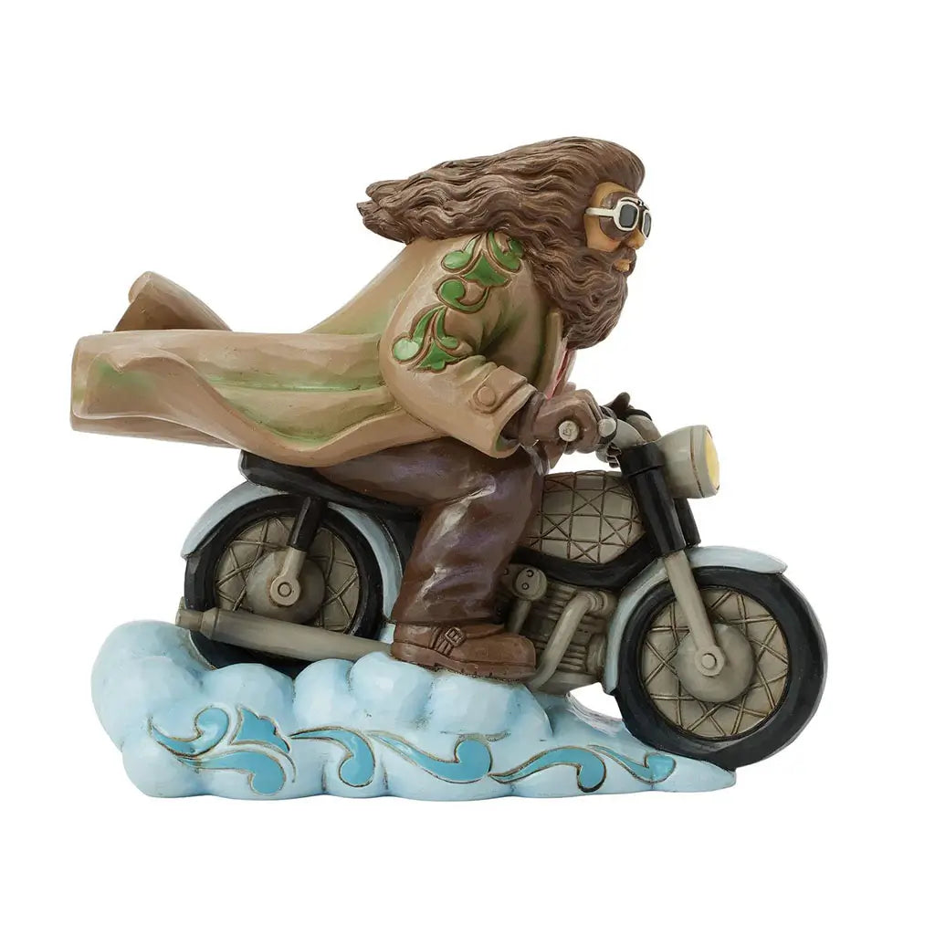 Left side of Jim Shore Hagrid figurine highlights detailed flying motorbike, billowing tan coat with green trim, and sculpted cloud base for display.