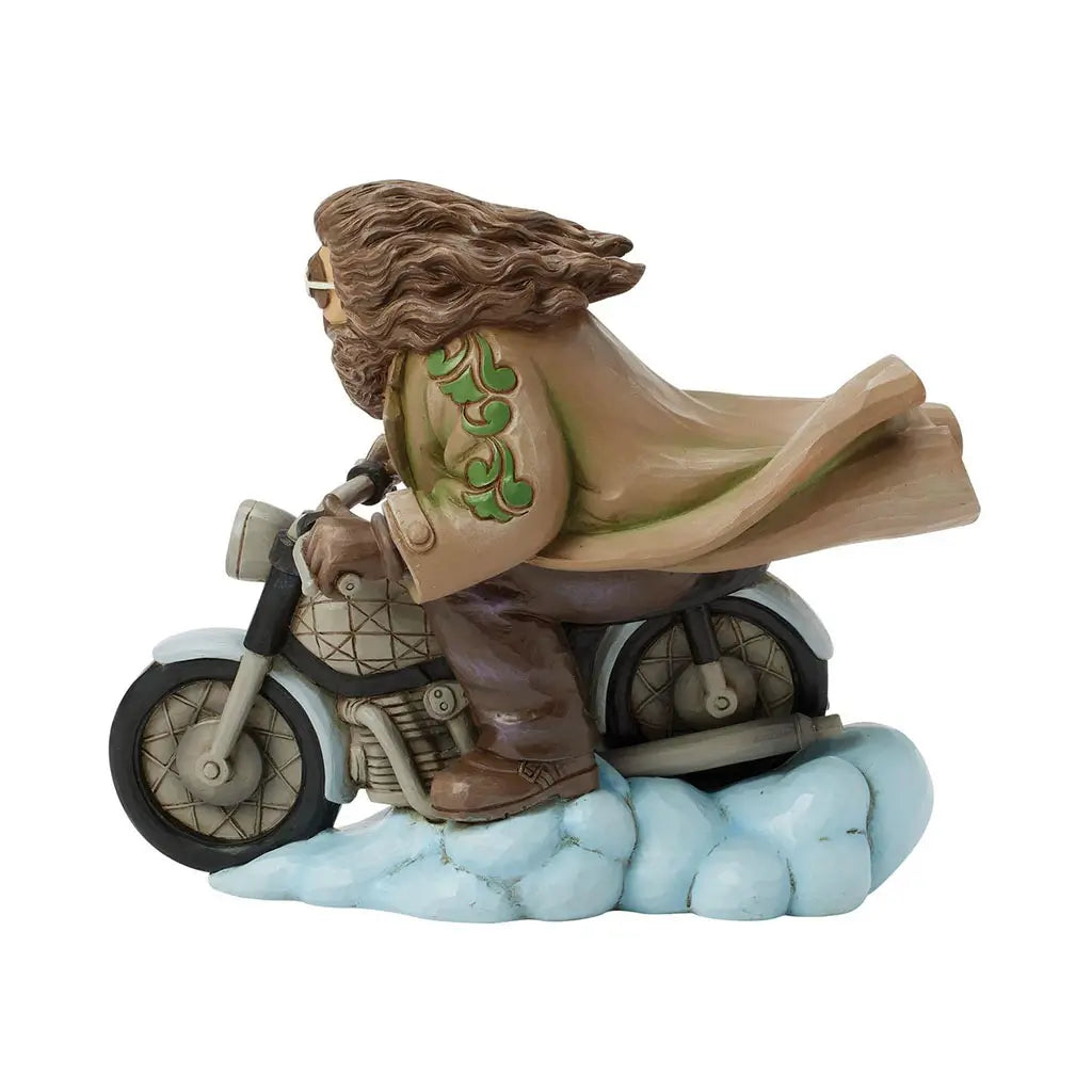 Right side perspective of Jim Shore Harry Potter figurine shows Hagrid leaning forward on enchanted motorbike, coat flowing, with swirling cloud platform.