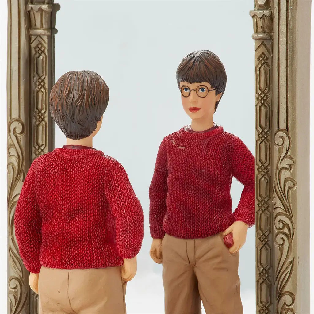 Close-up of Jim Shore Harry Potter figurine reveals textured red sweater, glasses, and reflection in detailed Mirror of Erised with ornate carved golden frame.