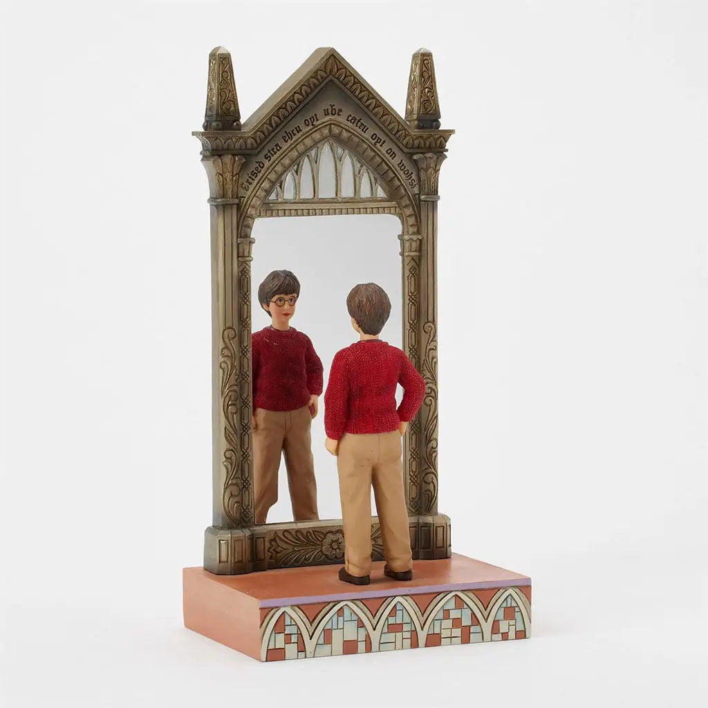 Angled figurine of Harry Potter by Jim Shore depicts Harry staring into Mirror of Erised, framed with intricate gold details and gothic-style pointed top.