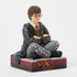 Angled view of Harry Potter figurine by Jim Shore, detailed with folded arms, wand in hand, maroon tie, and decorative scroll accents on trousers and base.