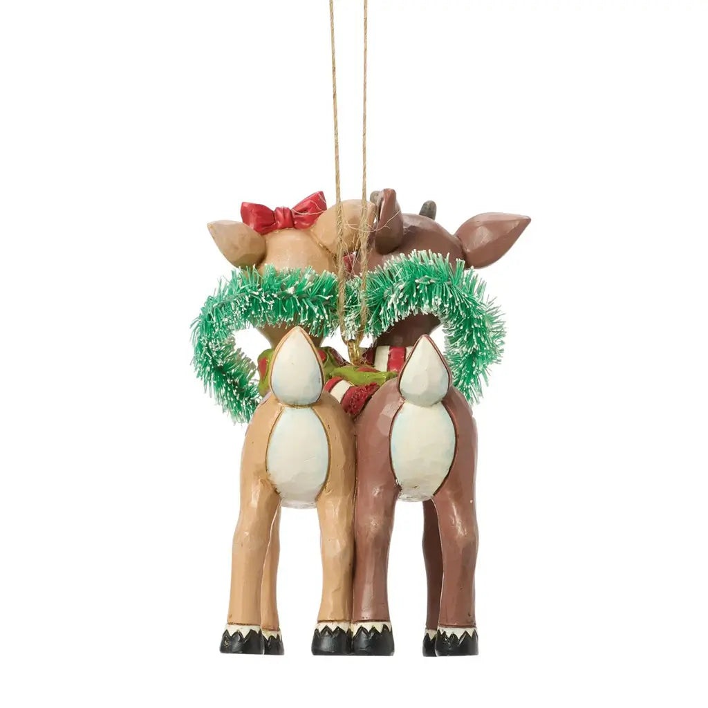 Back view of Jim Shore Rudolph and Clarice heart wreath ornament, featuring folk art carving details, green tinsel heart, and hanging gold cord.