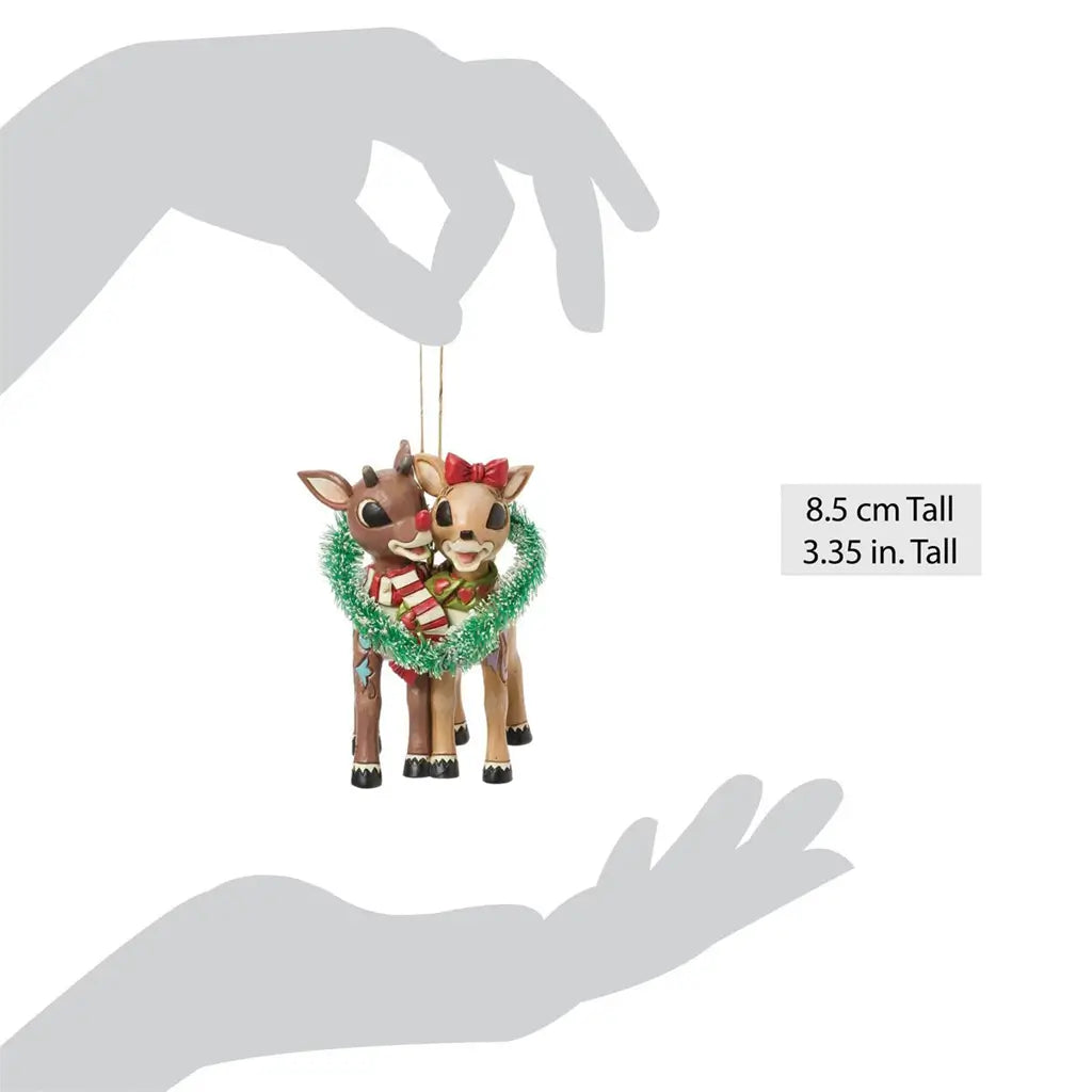 Scale view of Jim Shore Rudolph and Clarice ornament, measuring 3.35 inches tall, with detailed hand-painted patterns and festive wreath design.