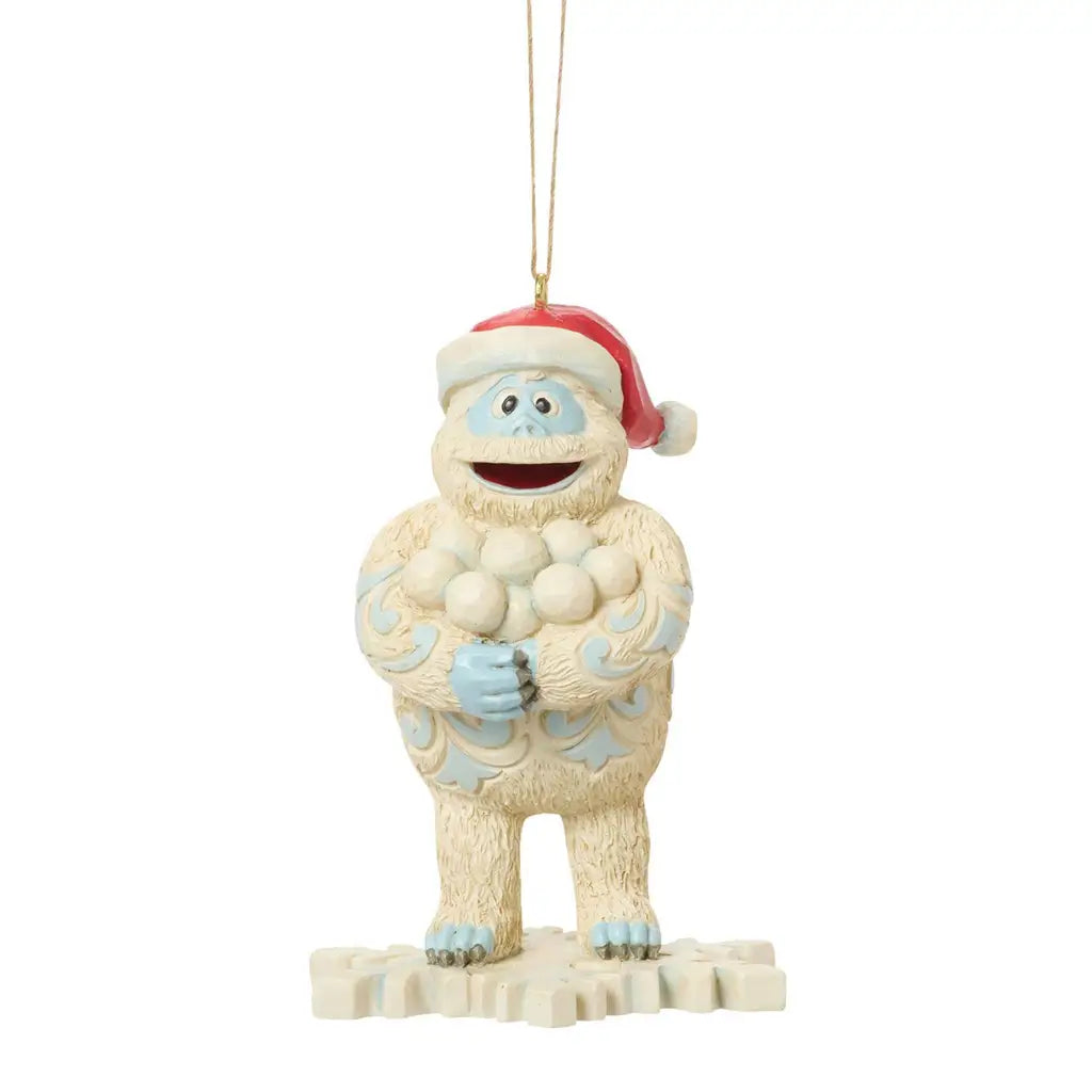 Front view of Jim Shore Bumble ornament, smiling with a bundle of snowballs, wearing a Santa hat, standing on a snowflake base.