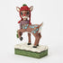 Festive Rudolph figurine with red knit hat, green pom-pom, and purple scarf, standing with raised hoof on snowy base with green textured trim, viewed at front angle.