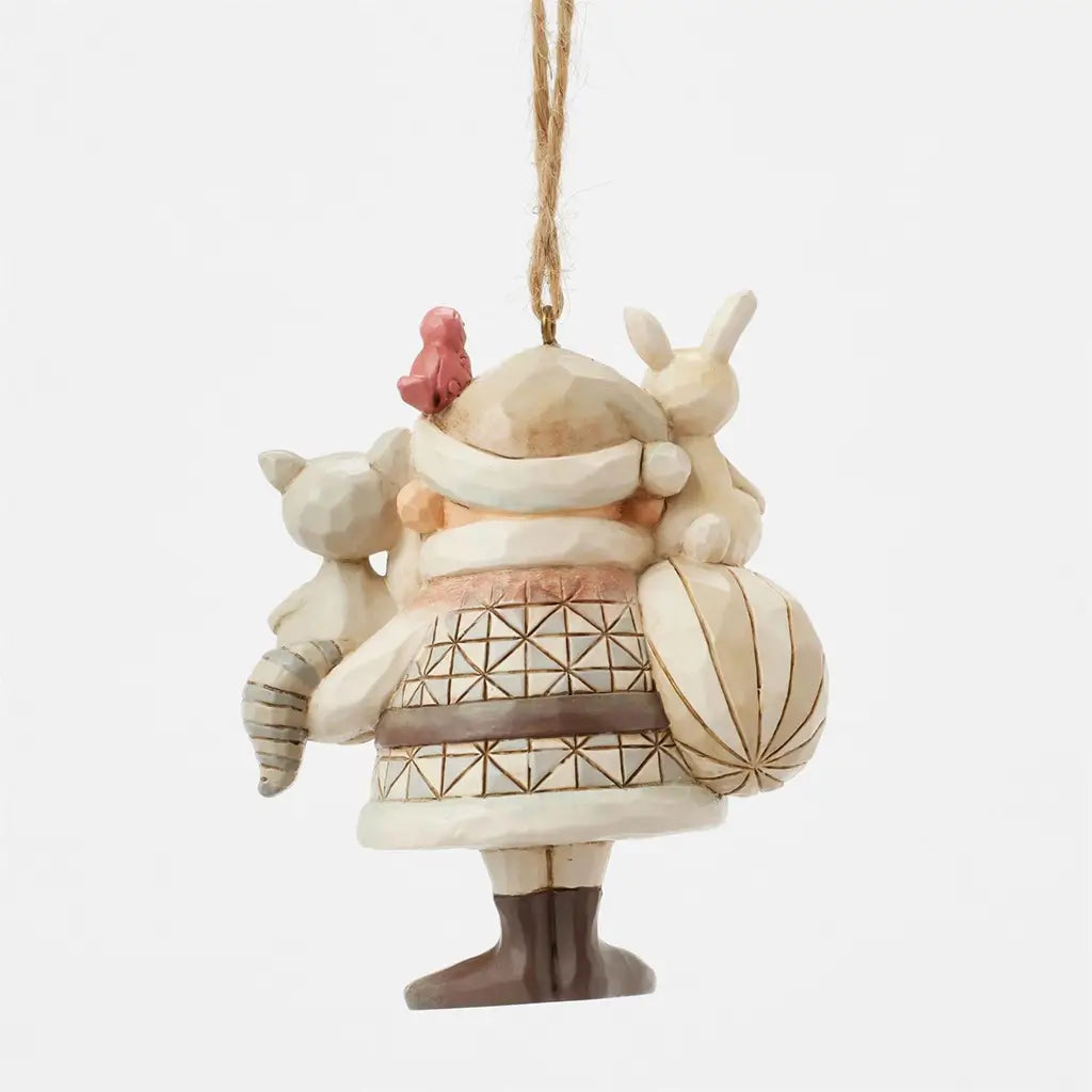Cream and brown Jim Shore Santa ornament with geometric patterns, holding a bunny, raccoon, and red bird, carrying a sack, viewed from back against plain white background.