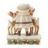Back view of cream and brown Jim Shore Santa figurine with arms around two reindeer on snowy base, holly and pinecone trim, set against plain white background.