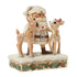 Angled view of Jim Shore cream and brown Santa figurine holding two reindeer, one with red bow, on snowy base with pinecone and holly design, against white background.