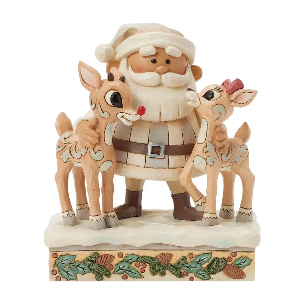 Front view of Jim Shore cream Santa figurine with white beard, hugging two reindeer, one with red nose, on snow base trimmed with holly leaves and pinecones.