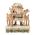 Front view of Jim Shore cream Santa figurine with white beard, hugging two reindeer, one with red nose, on snow base trimmed with holly leaves and pinecones.