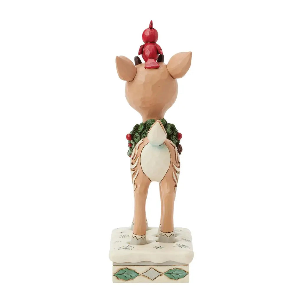 Decorative Rudolph figurine with a red ornament on its head, wearing a green wreath, on a white background.