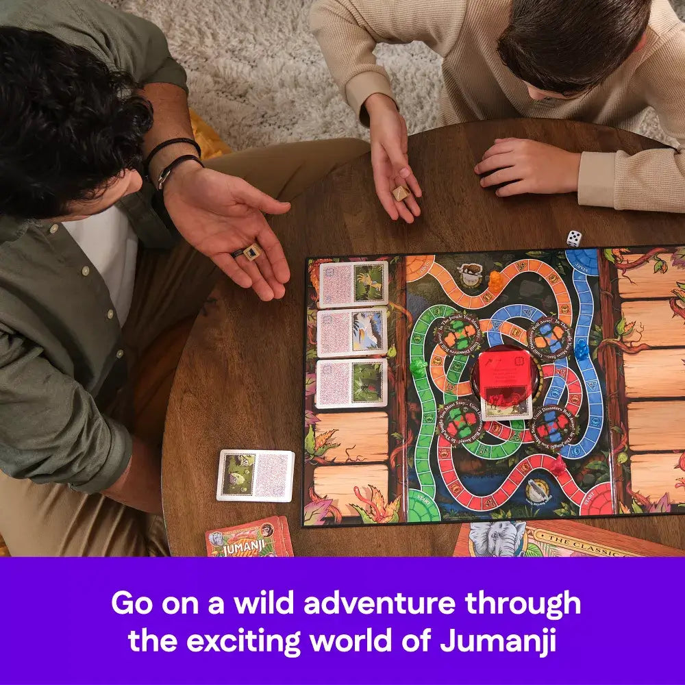 Two players at a round wooden table playing Jumanji board game, rolling dice and using decoder while colorful jungle-themed board and cards fill center.