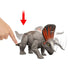 Jurassic World Zuniceratops Strike Attack feature shown in gray plastic with orange frill as a hand presses the tail, demonstrating head and frill motion for action play, illustrated on a clean white background.