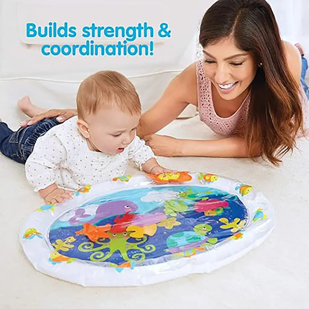 Smiling mother and baby play on floor with Kidoozie Pat 'n Laugh Water Mat, featuring colorful floating sea creatures that encourage strength, coordination, and sensory development.