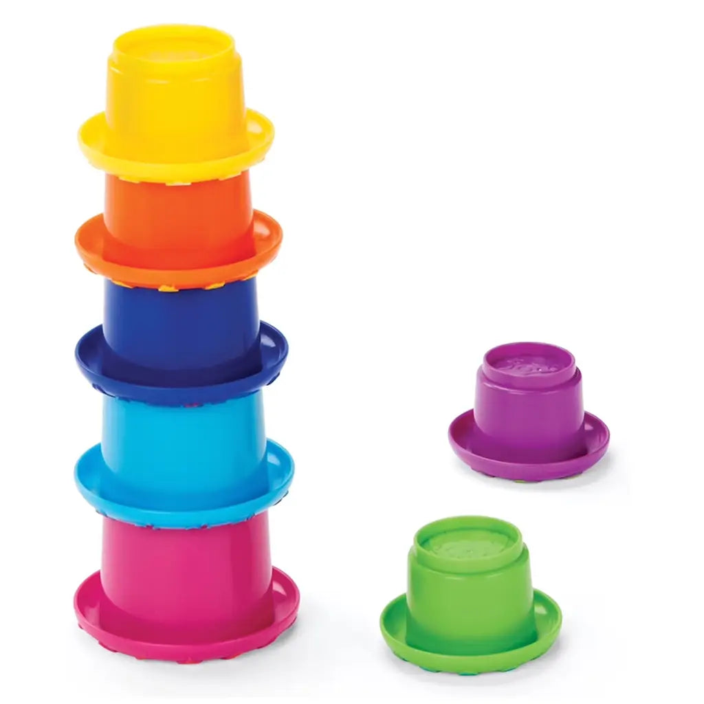 Seven brightly colored Kidoozie stacking cups in purple, green, yellow, orange, blue, and pink, arranged in a tall tower with two additional cups beside, promoting stacking and nesting play.